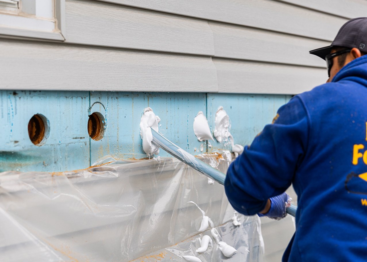Contractor injecting foam insulation into exterior wall in indiana